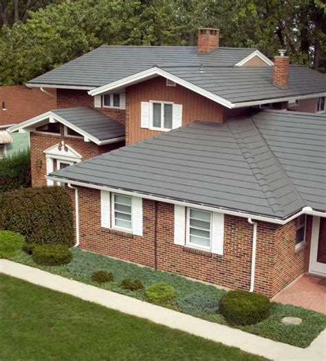 grey brick house with metal roof|black shingles on brick house.